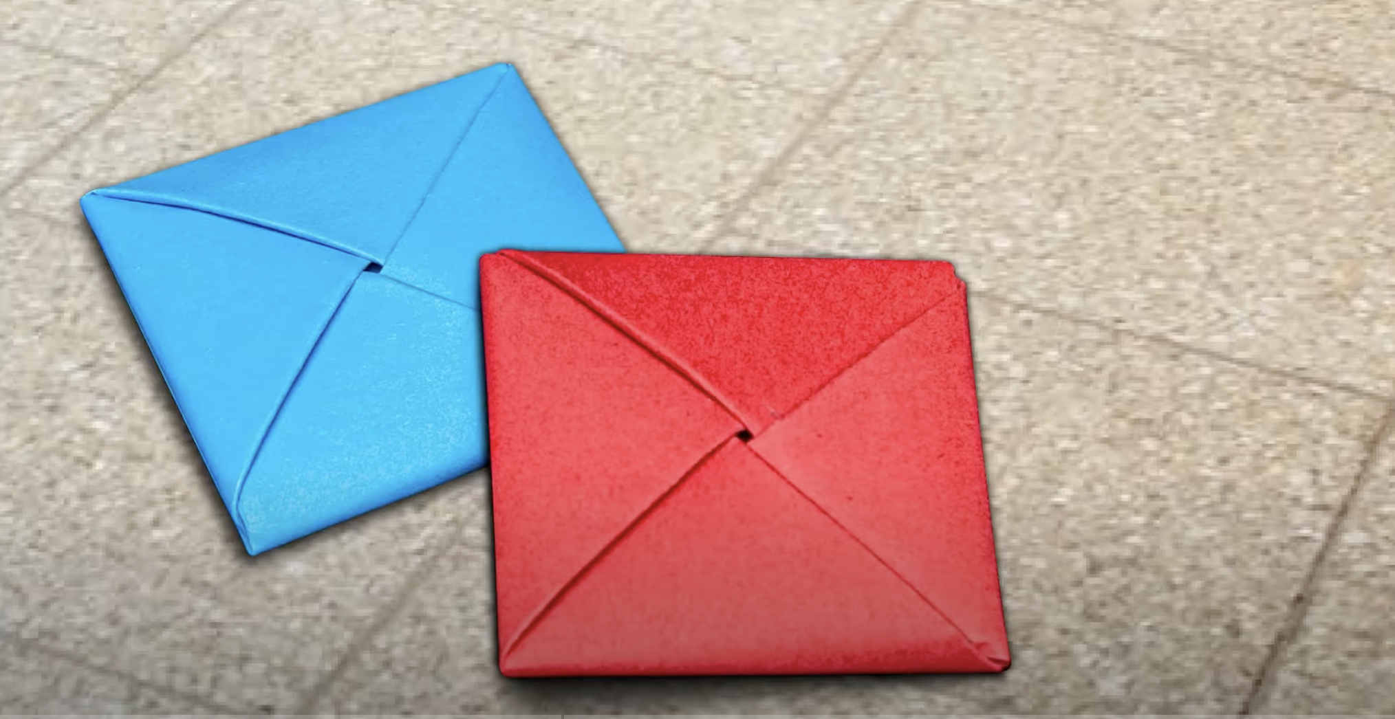 Folded ddakji squares made from colorful paper, ready for play in the traditional Korean flipping game.